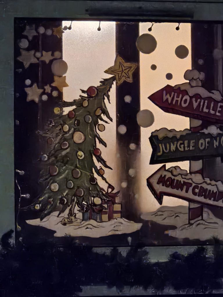 A window with a snowy image of a Christmas tree and a signpost, and the number 5